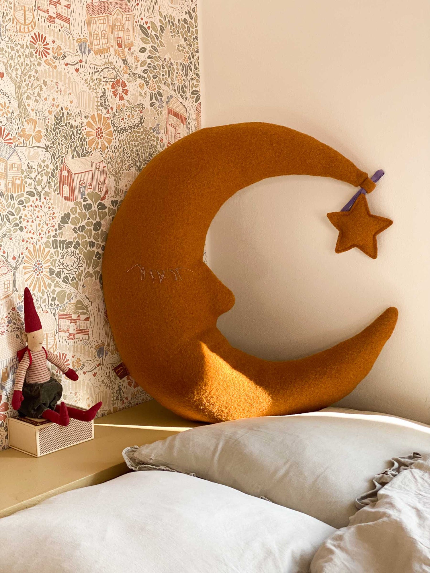 Großes Mondkissen als langlebiges Geschenk zum Kindergeburtstag in Goldgelb und Sternanhänger aif Bett im skandinavischem Kinderzimmer