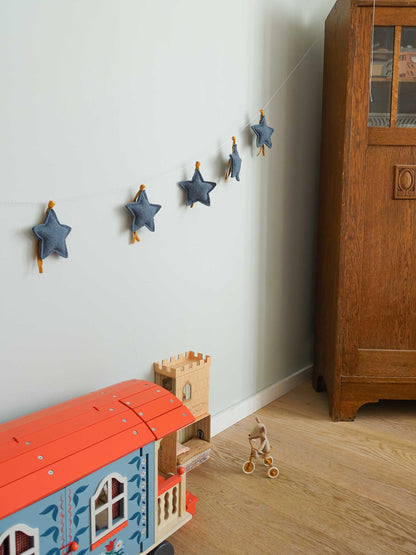 Blaue Sterngirlande in Kinderzimmer an Wand