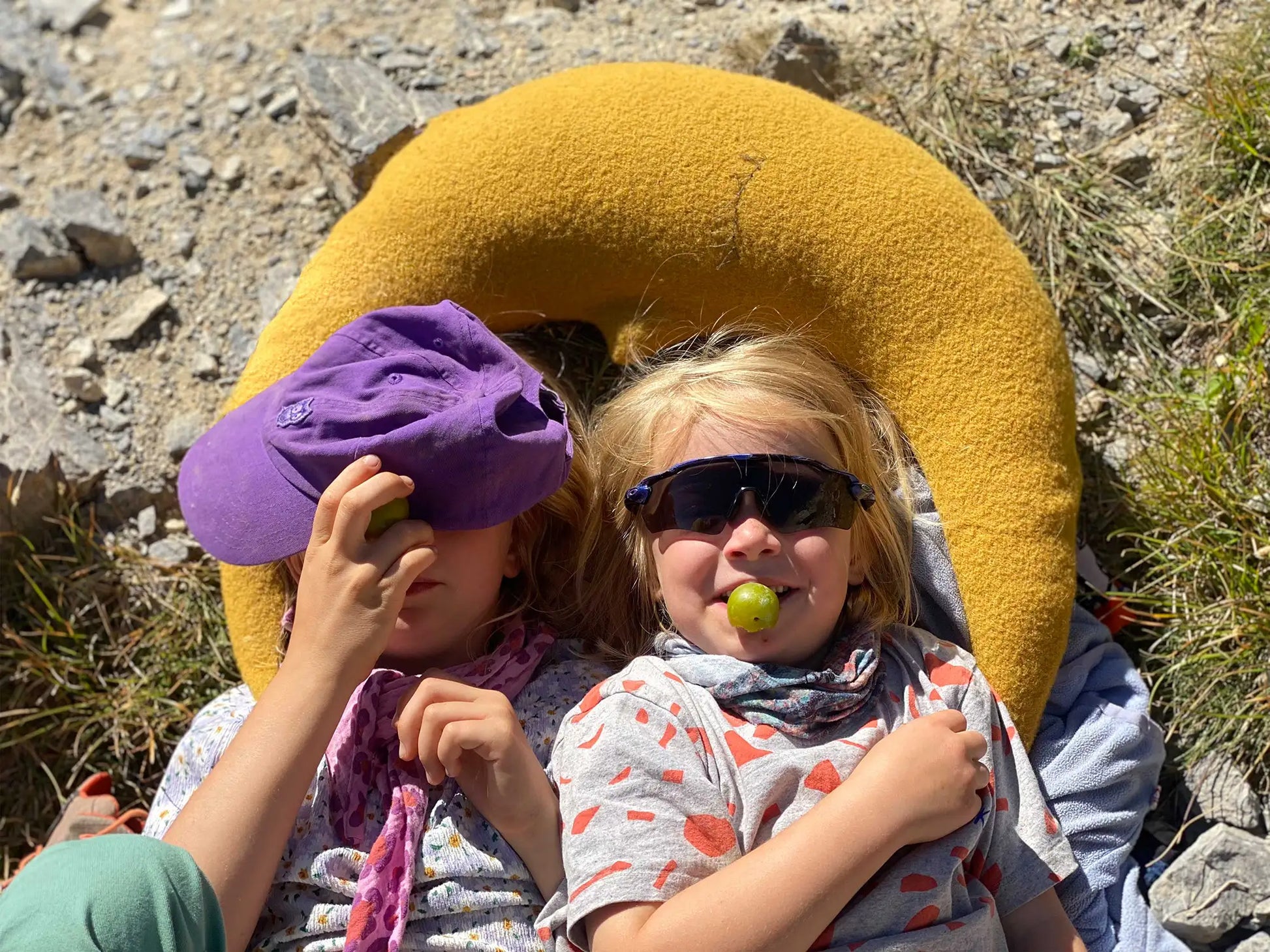 Kinder kuscheln draußen gemeinsam mit einem großen Mondkissen in Goldgelb