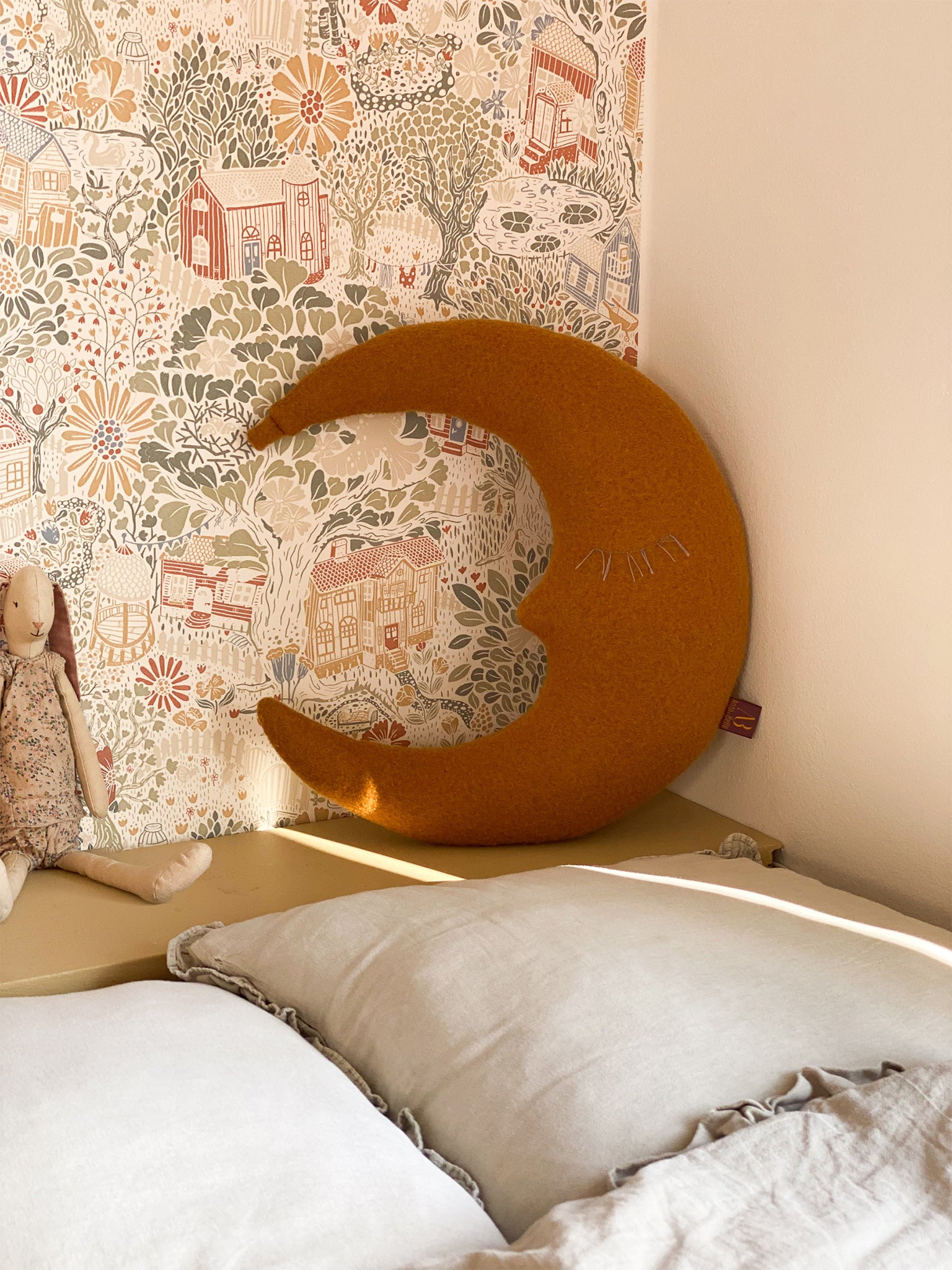 Kleines Mondkissen in Goldgelb im Kinderzimmer als dekoratives Accessoire im skandinavischen Stil